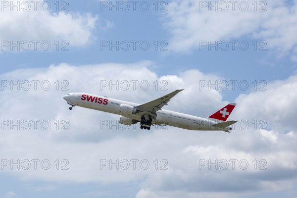 Swiss Airlines Passenger Airplane Flying Against Blue Sky and Clouds in a Sunny Summer Day From the Airport in Kloten, Zurich, Zurich Canton, Switzerland