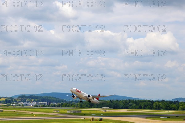 Swiss Airlines Passenger Airplane Take Off From the Runway and Flying Against Blue Sky and Clouds in a Sunny Summer Day From the Airport in Kloten, Zurich, Zurich Canton, Switzerland
