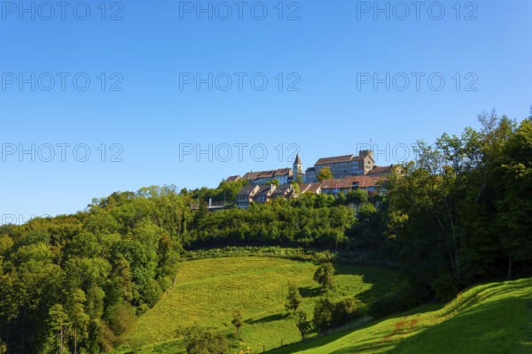 Medieval Old Town with House and Castle Tower on a Hill with Forest in a Sunny Summer Day with Blue Sky in Regensberg, Zurich Canton, Switzerland