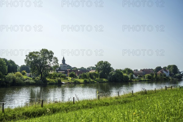 Rural view of a village with a church by the river, surrounded by green nature and a peaceful atmosphere, Weser, St Martin's Church, Hoya, Lower Saxony