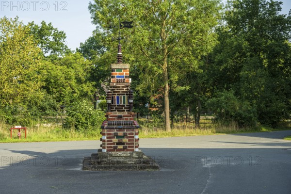 Colourful brick sculpture in a park with green trees in the background in the afternoon, Bücken, district of Nienburg Weser, Lower Saxony