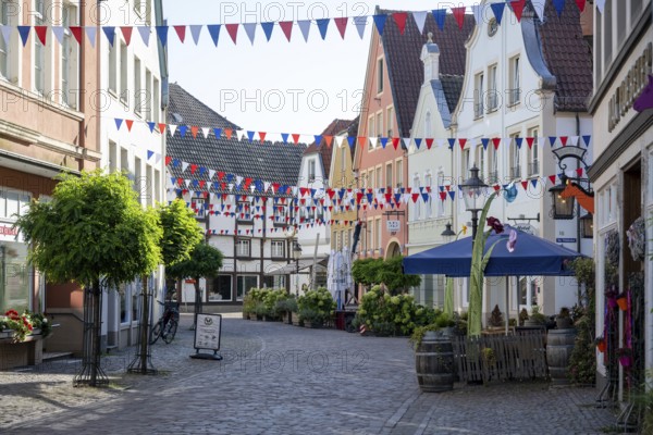 Colourfully decorated street in an old town with garlands and plants along the pavements, Warendorf, Münsterland, North Rhine-Westphalia