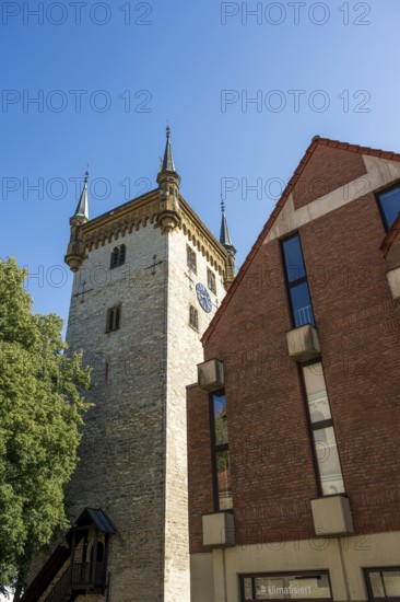 Historic tower and modern building, surrounded by trees, under a blue sky, tower of the old St Mary's Church, Warendorf, Münsterland, North Rhine-Westphalia