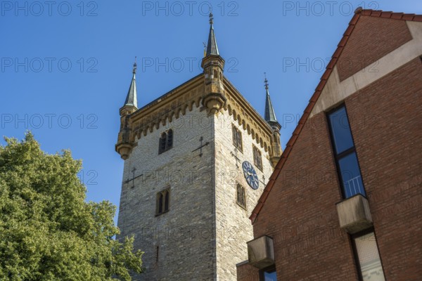 Old tower next to a modern building, in a clear blue sky, tower of the old St Mary's Church, Warendorf, Münsterland, North Rhine-Westphalia
