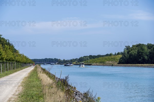 Canal with boats and clear sky. Calm water surrounded by nature and a gravel path, Dortmund-Ems Canal near Lüdinghausen, Münsterland, North Rhine-Westphalia