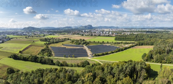Aerial view, panorama, solar modules, solar park, photovoltaics, power generation from solar energy, behind the city of Singen am Hohentwiel, on the horizon the Hegau mountains, district of Constance, Baden-Württemberg, Germany