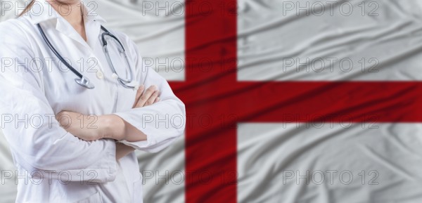 Doctor with crossed arms on England flag. England health and care concept. Female doctor on England flag