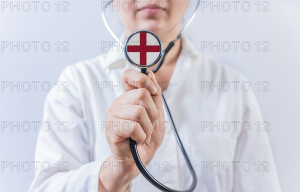 Female doctor holding stethoscope with England flag. National health system of England