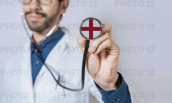 Doctor holding stethoscope with England flag. England health and care concept. England flag on stethoscope