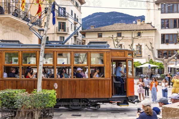 Vintage tramcar passing through town square in the centre of Sóller with tourists, Soller, Mallorca, Spain