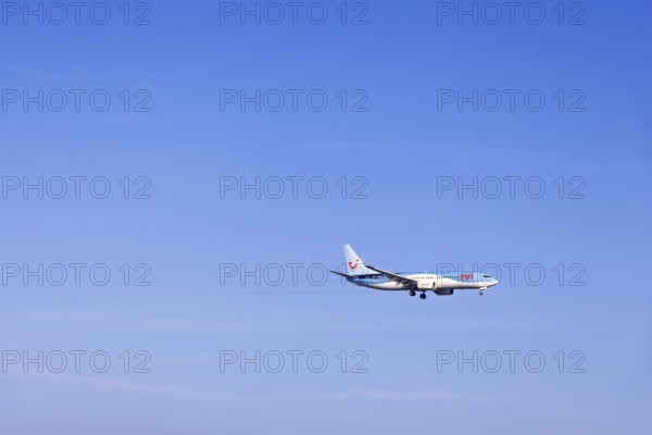 Passenger plane with tourists from the travel company Tui flying on a clear blue sky, Mallorca, Spain