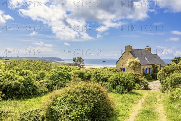Idyllic old stone house with a seascape view at the sea horizon in a coastal landscape a sunny summer day, Crozon peninsula, Bretagne, France