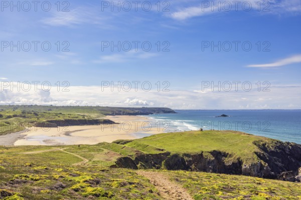 Sunny seascape view in a coastal landscape with a sandy beach and a rocky coastline from a meadow, Crozon peninsula, Bretagne, France