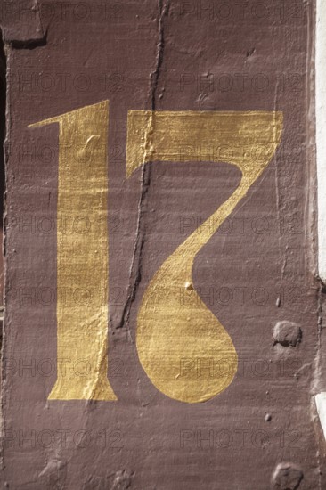 Golden house number plate number seventeen on a half-timbered house in the old town centre, Hamelin, Lower Saxony, Germany