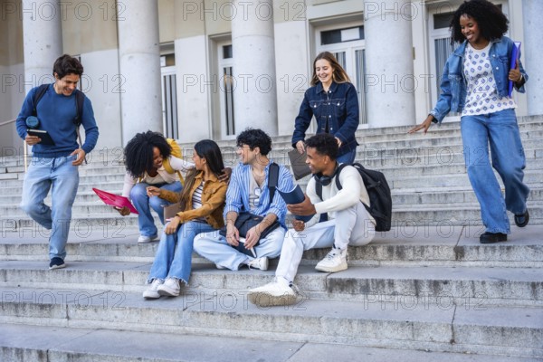 Diverse young students chatting, laughing and walking on wide stone campus steps by a university building, enjoying a casual outdoor study break and friendly conversation