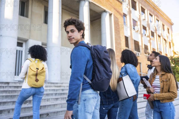 Group of young adult students walking on a university campus building staircase, representing diversity and a new generation pursuing higher education and learning