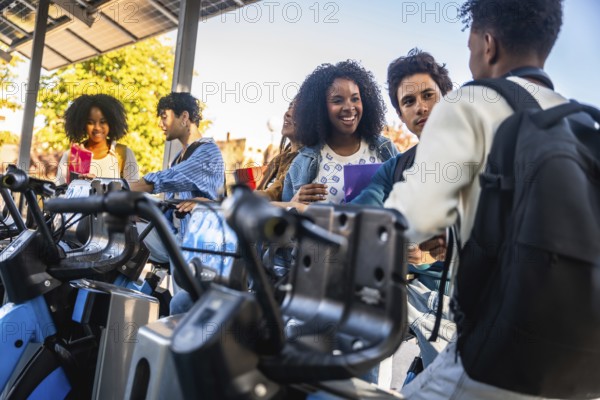 Young diverse students are talking and smiling at a public bicycle sharing station, using sustainable and eco friendly transportation on university campus