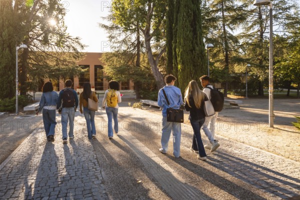 Young diverse students with backpacks walking together along a paved path, heading towards a university building on a sunny day, showcasing education, friendship, and campus life