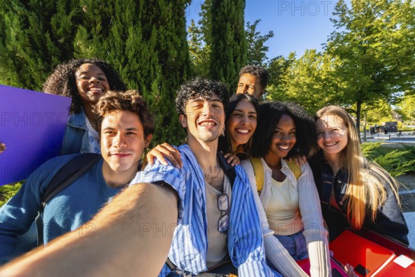 Diverse group of happy young adult students smiling while taking a group selfie together on university campus, representing friendship and modern student life
