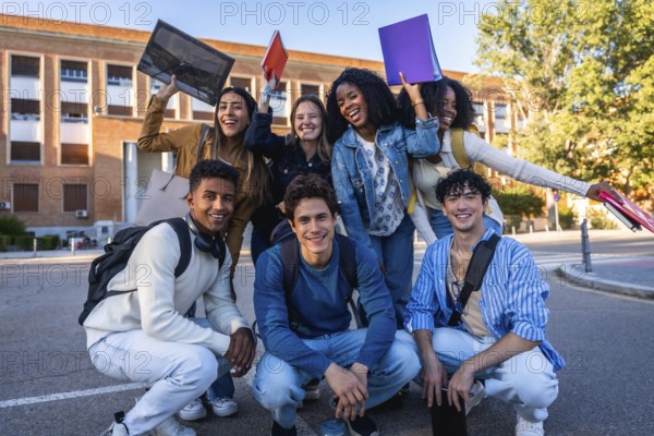 Diverse group of smiling university students on campus holding folders and backpacks, enjoying sunny day together friends, classmates celebrating education, unity and future goals