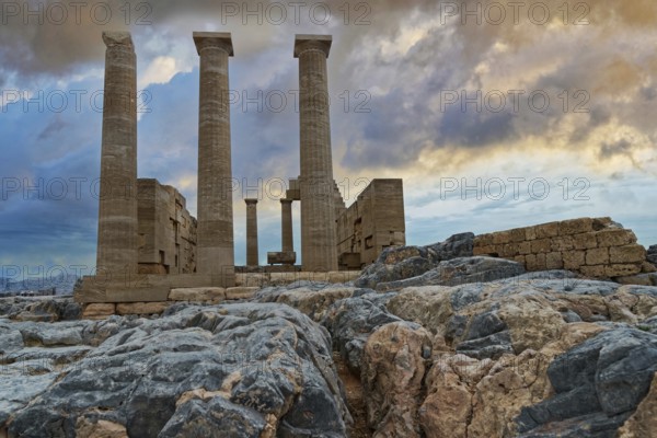 Ancient columns of the Temple of Athena on the Acropolis of Lindos in front of a dramatic sky and rocks in the foreground, Acropolis, Lindos, Rhodes, Island, Greece
