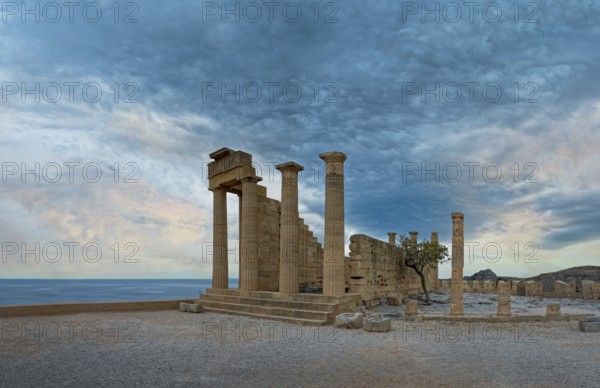 Ancient ruins of the Temple of Athena on the Acropolis of Lindos with columns in front of a calm sea and dramatic sky, Acropolis, Lindos, Rhodes, Island, Greece