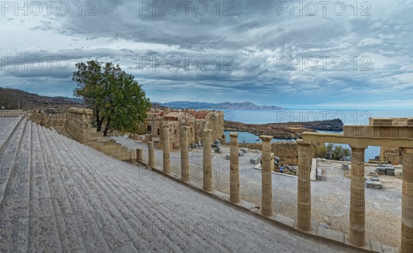 Ancient columns and staircase of the Acropolis of Lindos with a view of the sea and cloudy sky, Acropolis, Lindos, Rhodes, Island, Greece