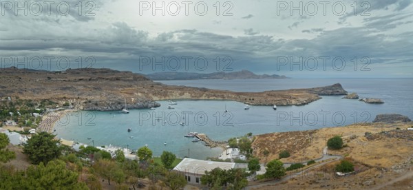 Harbour and coast of Lindos with boats and cloudy sky, Acropolis, Lindos, Rhodes, island, Greece