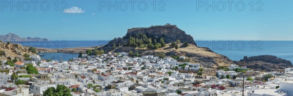 Panoramic view over the coastal landscape of Lindos with Acropolis and hills in the background, Acropolis, Lindos, Rhodes, Island, Greece