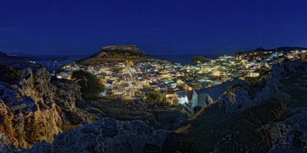 View of the illuminated town of Lindos with the ancient Acropolis under a starry sky with the sea, Acropolis, Lindos, Rhodes, Island, Greece