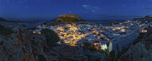 Panorama of picturesque Lindos and the ancient Acropolis at night with illuminated buildings and sea, Acropolis, Lindos, Rhodes, Island, Greece