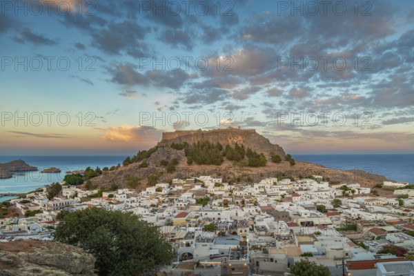View of picturesque Lindos with the ancient Acropolis on a hill surrounded by the sea at sunset, Acropolis, Lindos, Rhodes, Island, Greece