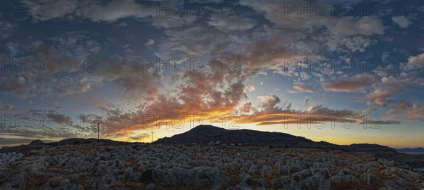 Dramatic landscape of Lindos with a mountain in the background and colourful sunset in the sky, Acropolis, Lindos, Rhodes, Island, Greece