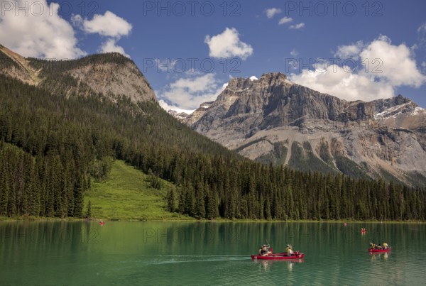 Canoes on the stunning Emerald Lake with the Canadian Rocky Mountains terrain and lush forests within Yoho National Park in Alberta, Canada, North Canada