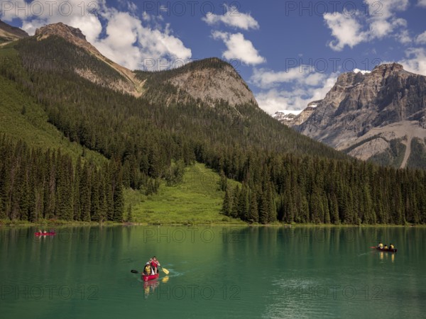 A group canoeing on Emerald Lake with the dramatic Canadian Rocky Mountains as a scenic backdrop within Yoho National Park in Alberta, Canada, North Canada