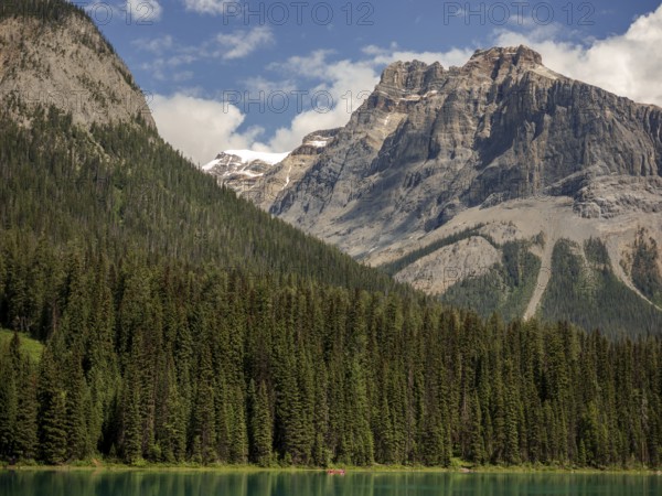 Scenic view of Emerald Lake and the Canadian Rocky Mountains with a dense forest backdrop within Yoho National Park in Alberta, Canada, North Canada