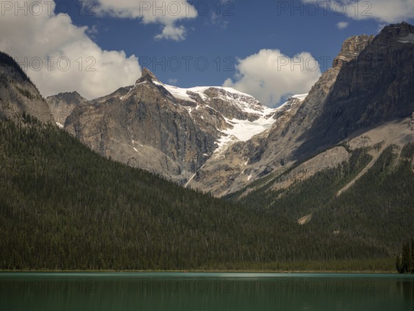 Snowy mountains of the Canadian Rocky Mountains and Emerald Lake with green forest expanse inside Yoho National Park, British Columbia, Canada, North America