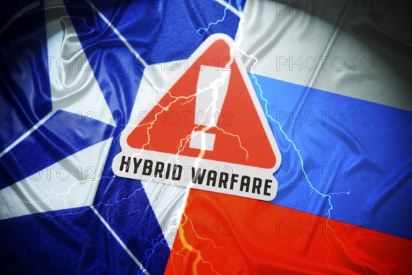 The flags of NATO and Russia with danger sign and inscription Hybrid Warfare, symbolic photo of hybrid warfare, photomontage