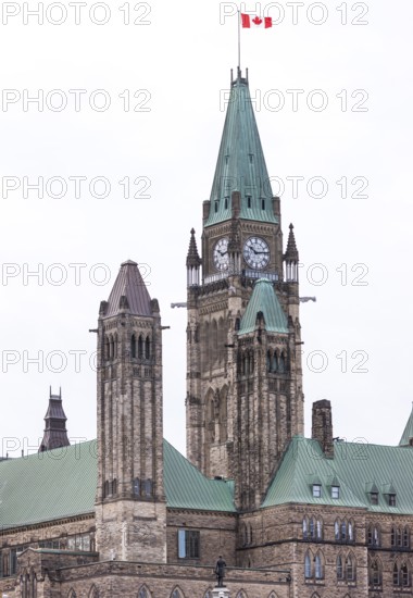 The Canadian parliament building with a clock tower and green roof under an overcast sky in Ottawa, Ontario, Canada, North America
