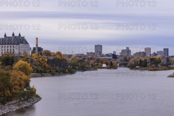 A city skyline seen across a the Ottawa River during an overcast autumn day in Ottawa, Ontario, Canada, North America