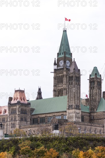 The Canadian parliament building with a prominent clock tower and Canadian flag in Ottawa, Ontario, Canada, North America