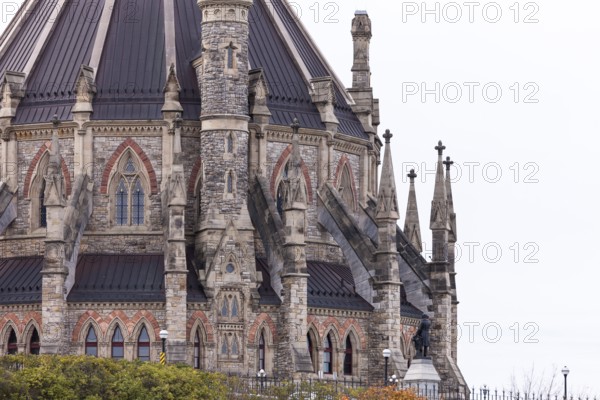 A detailed view of a gothic-style stone building of the Canadian Parliament Buildings with intricate spires in Ottawa, Ontario, Canada, North America