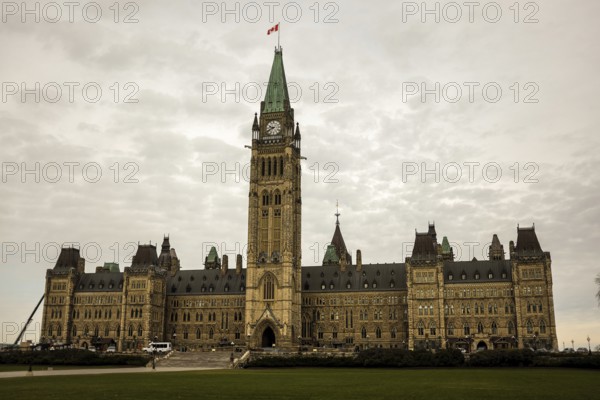 The Canadian parliament building with a central tower on a cloudy day, featuring gothic revival architecture in Ottawa, Ontario, Canada, North America