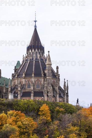 The stately Canadian Parliament Buildings with their Gothic structure with a tall spire and autumn foliage, capturing both architectural and seasonal beauty in Ottawa, Ontario, Canada, North America