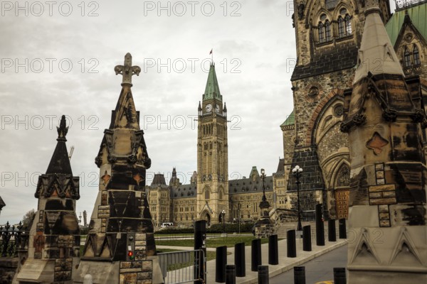 View of the Canadian parliament building from the foreground of stone monuments, featuring gothic architecture in Ottawa, Ontario, Canada, North America