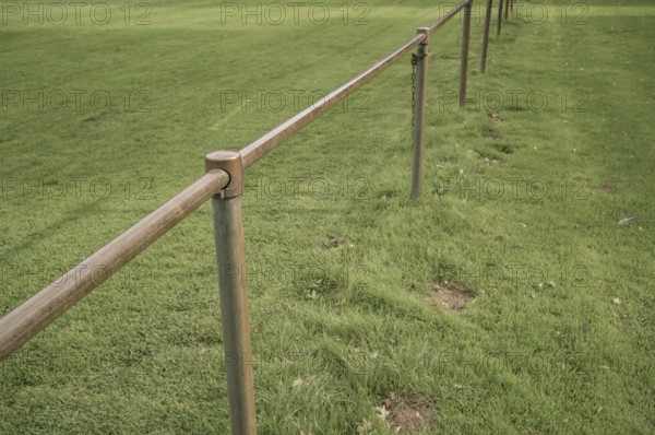 Borken, NRW, Germany, Metal railing creating a barrier along the edge of a lush green grass field