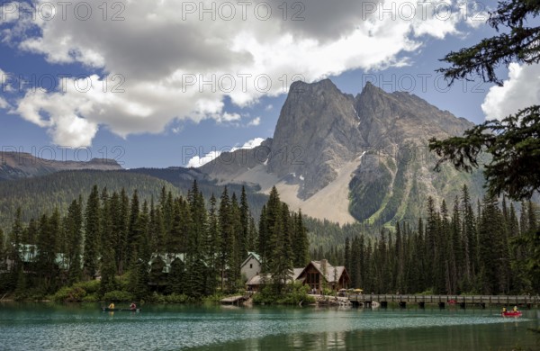 Scenic view of Emerald Lake and the Canadian Rocky Mountains with cabins from Emerald Lake Lodge and surrounding forest under a cloudy sky inside Yoho National Park, British Columbia, Canada, North America