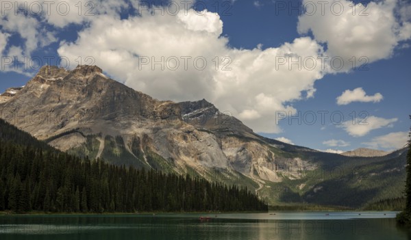 Serene mountain view of the Canadian Rocky Mountains with clear Emerald Lake reflecting a dramatic sky and lush forest inside Yoho National Park, British Columbia, Canada, North America
