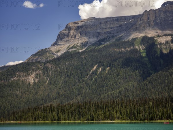 Tranquil Emerald Lake with clear blue water and forested mountains of the Canadian Rocky Mountains in the background inside Yoho National Park, British Columbia, Canada, North America