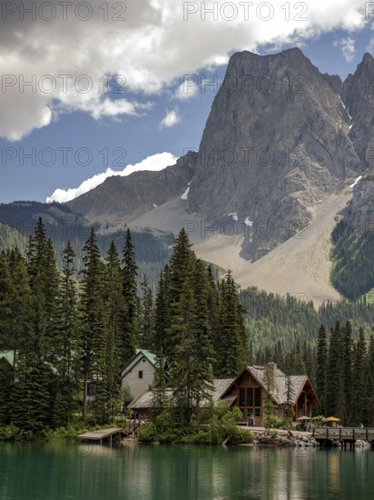 Cabin by a tranquil Emerald Lake with towering mountains of the Canadian Rocky Mountains and a dramatic sky inside Yoho National Park, British Columbia, Canada, North America